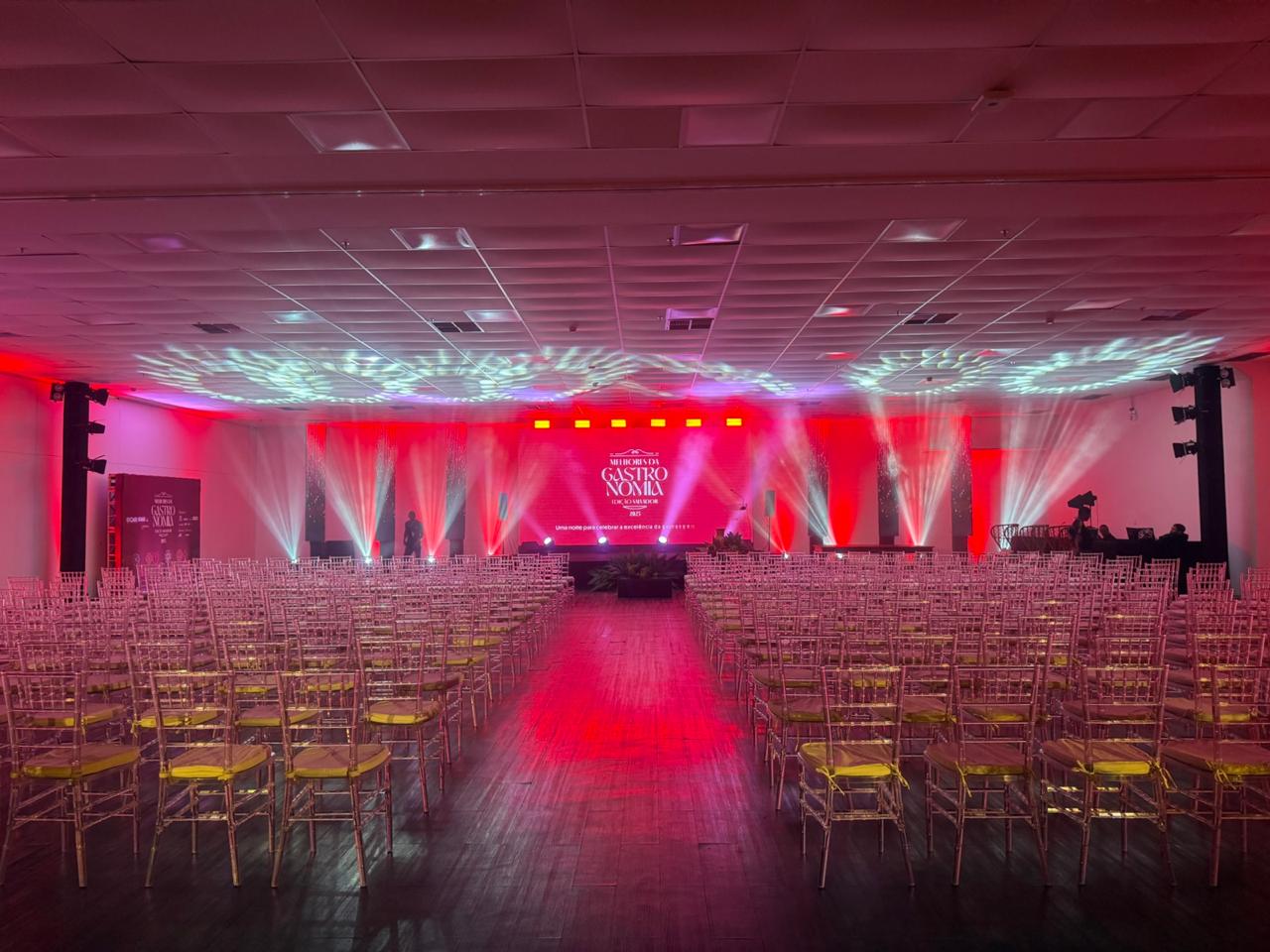 Premiação Melhores da Gastronomia com iluminação rosa e efeitos aéreos